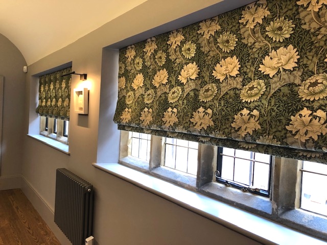 Green floral curtains used to create roman blinds